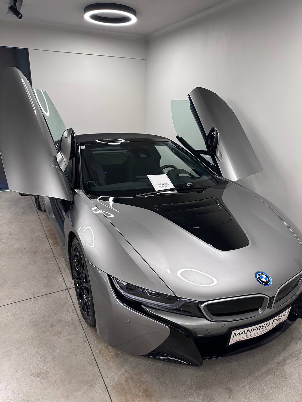 Silver BMW i8 Roadster at the dealership during our inspection, with both doors raised