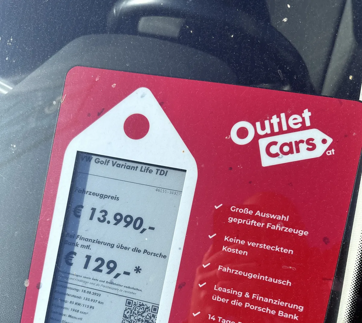 A dealer windscreen card displaying a car price of 13,990 euros and a financing payment of 129 euros per month